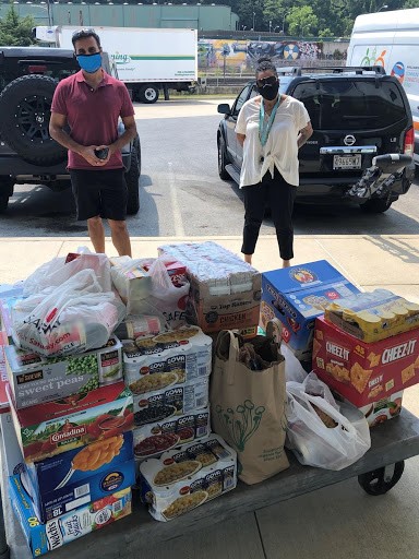 Lokesh Sayal and Lisa Clark-Hawkins in front of a pallet of donated food